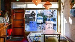 Een gezellig interieur met een houten bank, een tafel en uitzicht op de straat.