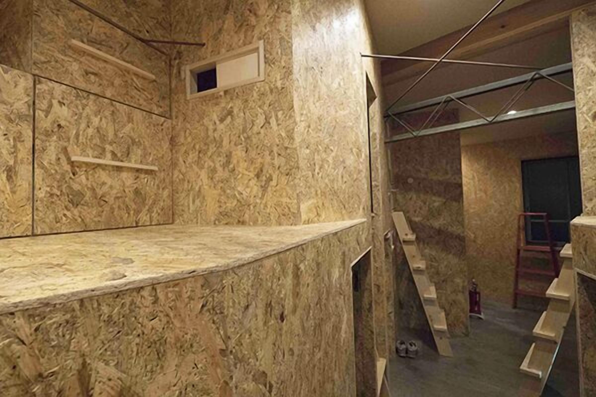 A room with a marble wall, a wooden bench, and a ladder.