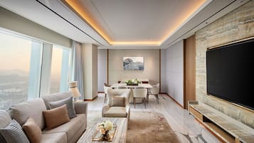 Uma sala de estar moderna com uma janela grande, um espaço de jantar e uma televisão de tela plana.