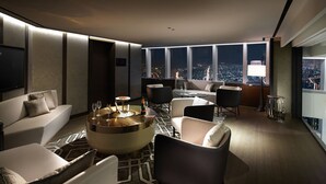 Un salón moderno con vistas a la ciudad, una mesa redonda de centro y muebles contemporáneos.