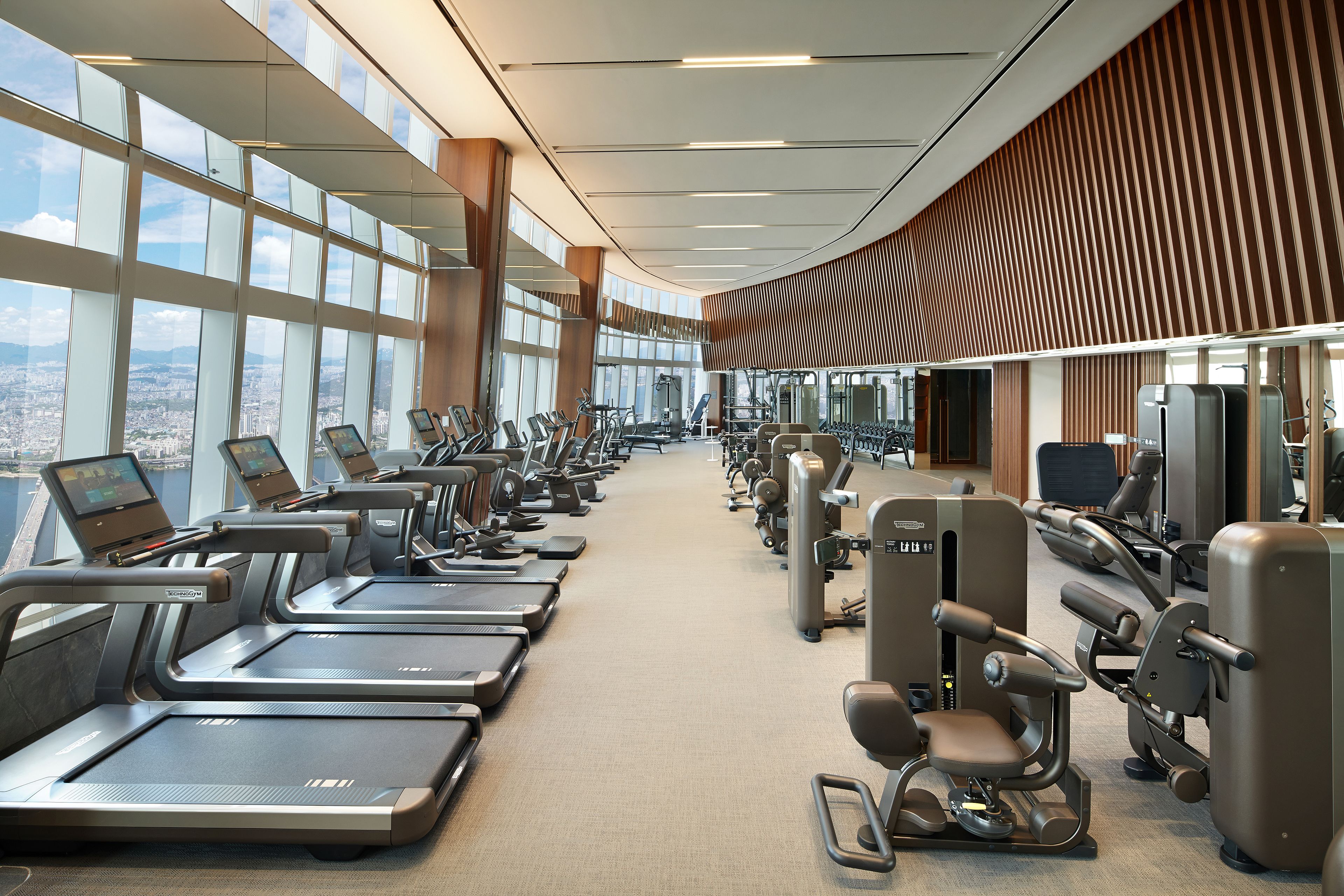 Une salle de sport moderne équipée de tapis de course, d’appareils de musculation et de matériel de cardio.