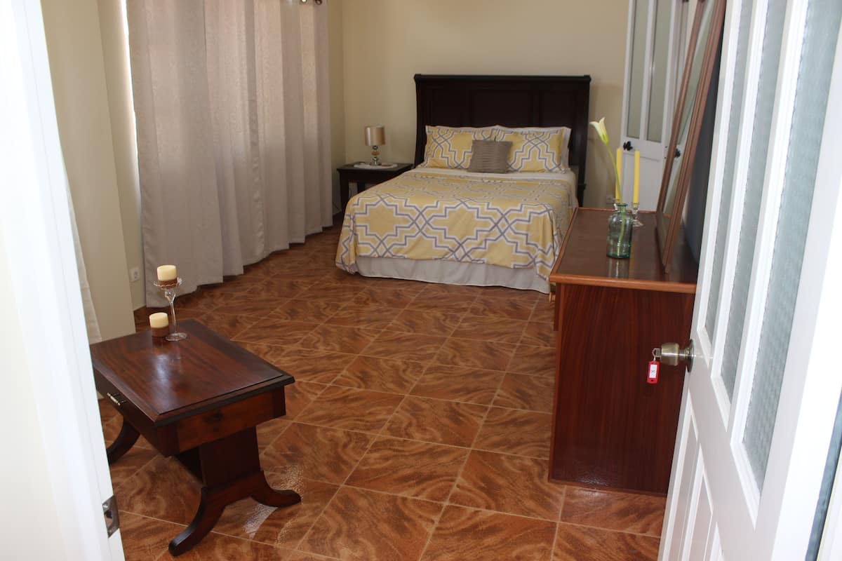 A bedroom with a bed, bedside table, and a nightstand.
