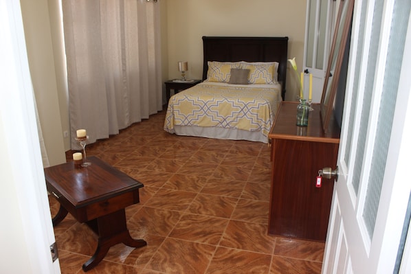 A bedroom with a bed, bedside table, and a nightstand.