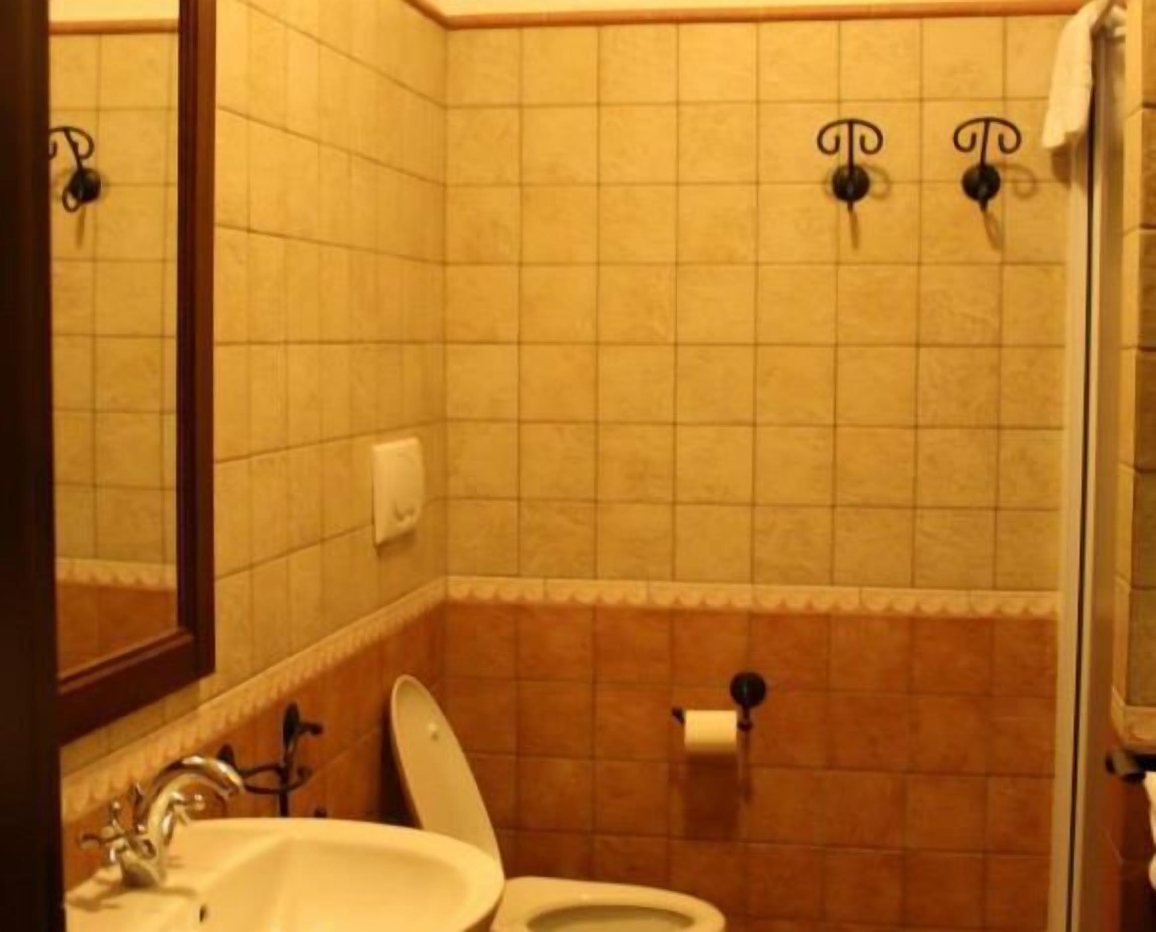 Un baño con lavamanos, inodoro y espejo.