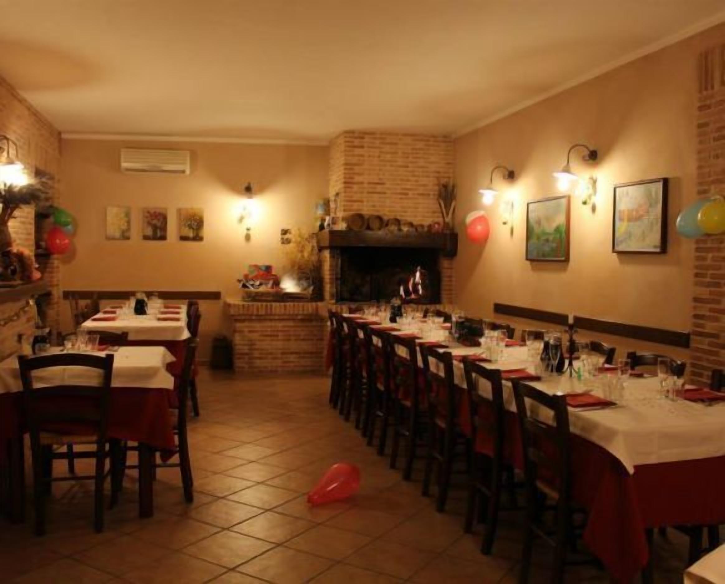 A restaurant with brick walls, a fireplace, and tables set for dining.