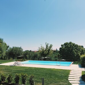A rectangular swimming pool with a clear blue water, surrounded by a grassy area and trees. - Angelucci Agriturismo con Camere e Agri Camping (Lanciano)