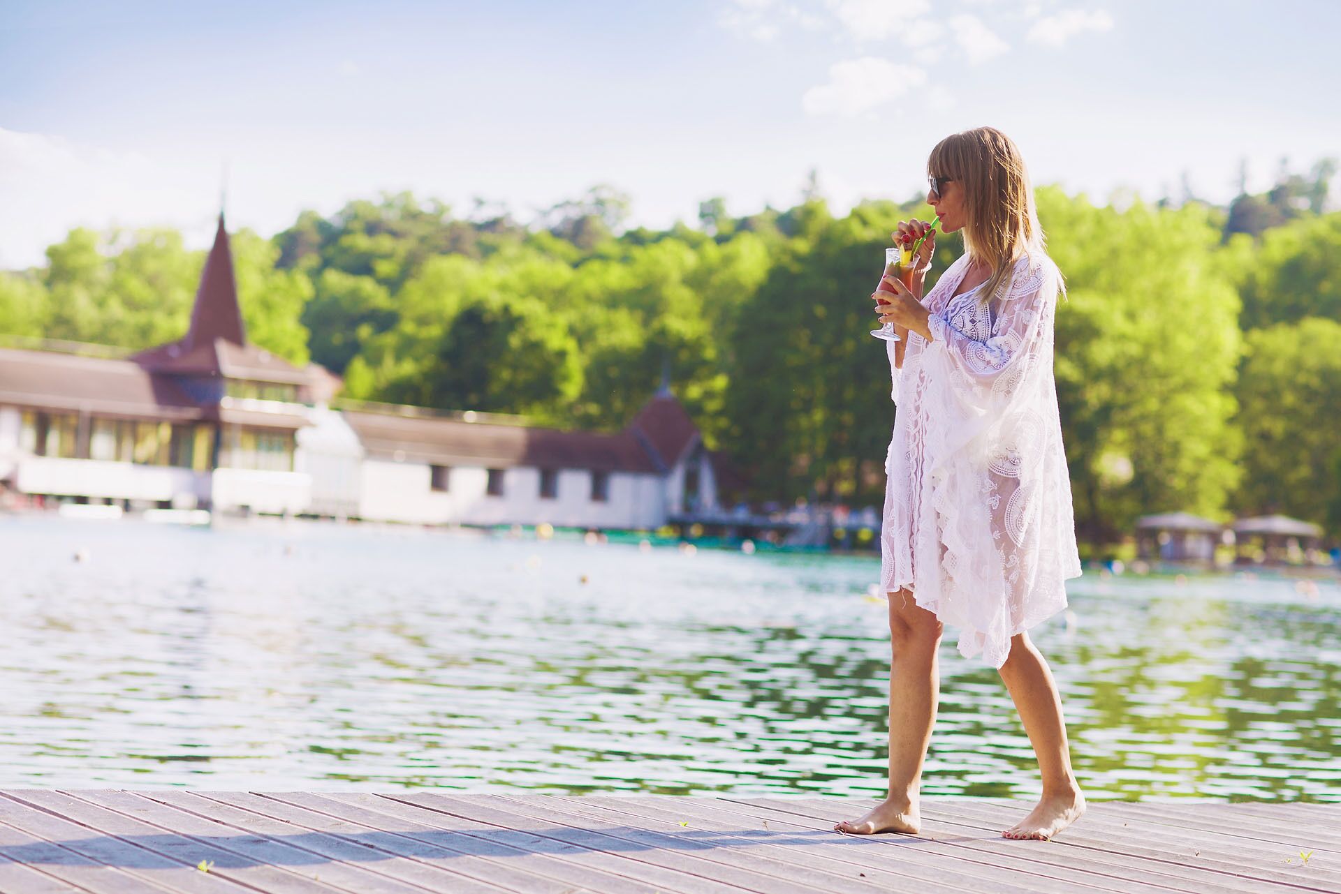 A wooden dock extending into a body of water with a building in the background.