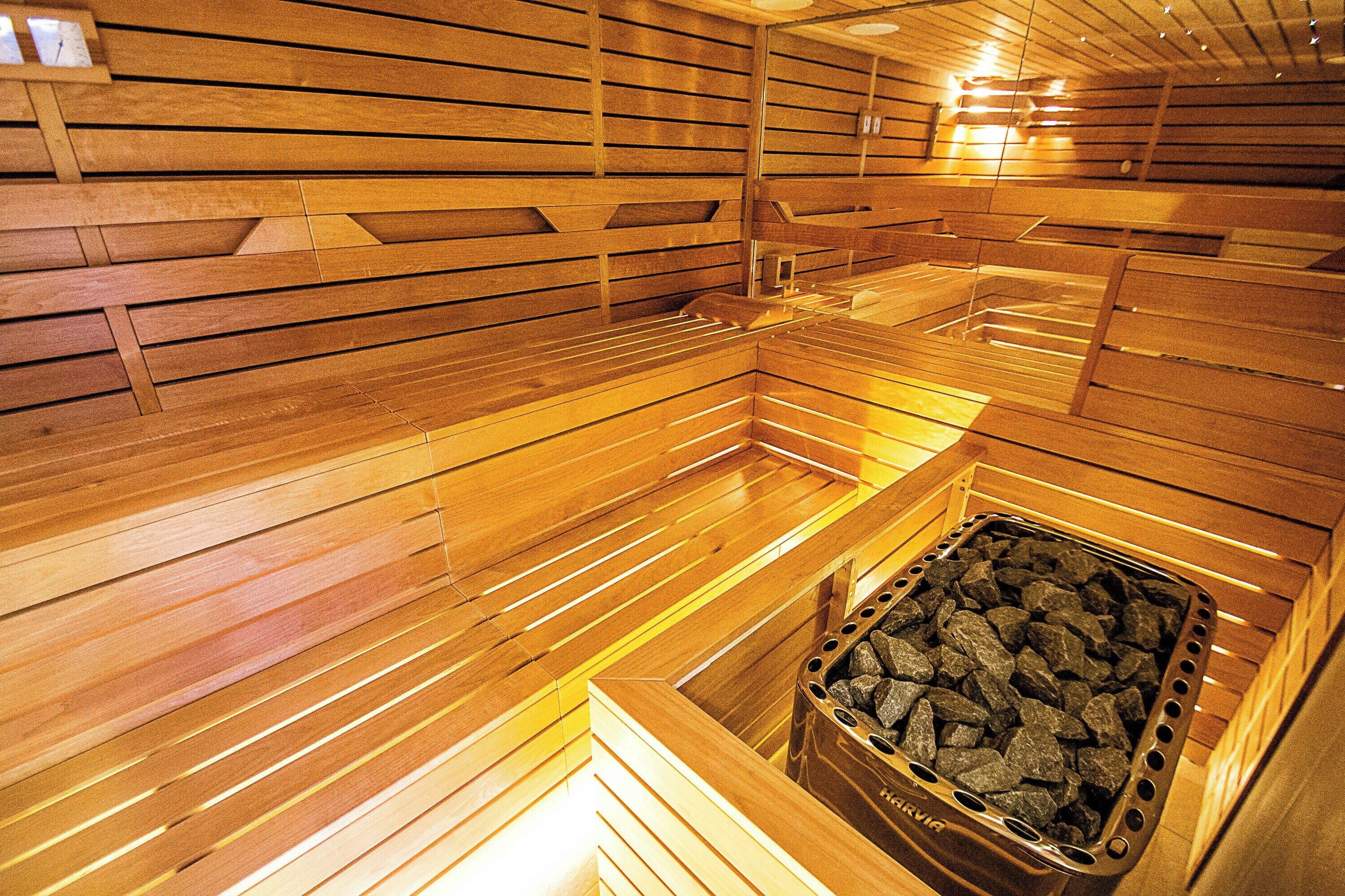 A sauna with wooden slats and a stone basin.