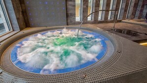Ein Whirlpool mit blau gefliestem Innenraum und Metallgeländer.