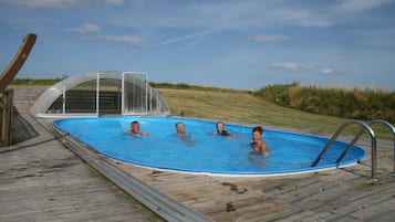 Enjoy a refreshing swim in the pool surrounded by a deck and a safety barrier.