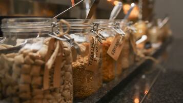 Glass jars with labels, possibly containing food items, arranged on a shelf.