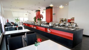 A modern restaurant with a central buffet area, black and red decor, and pendant lighting. - Crystal Lodge (Kota Bharu)
