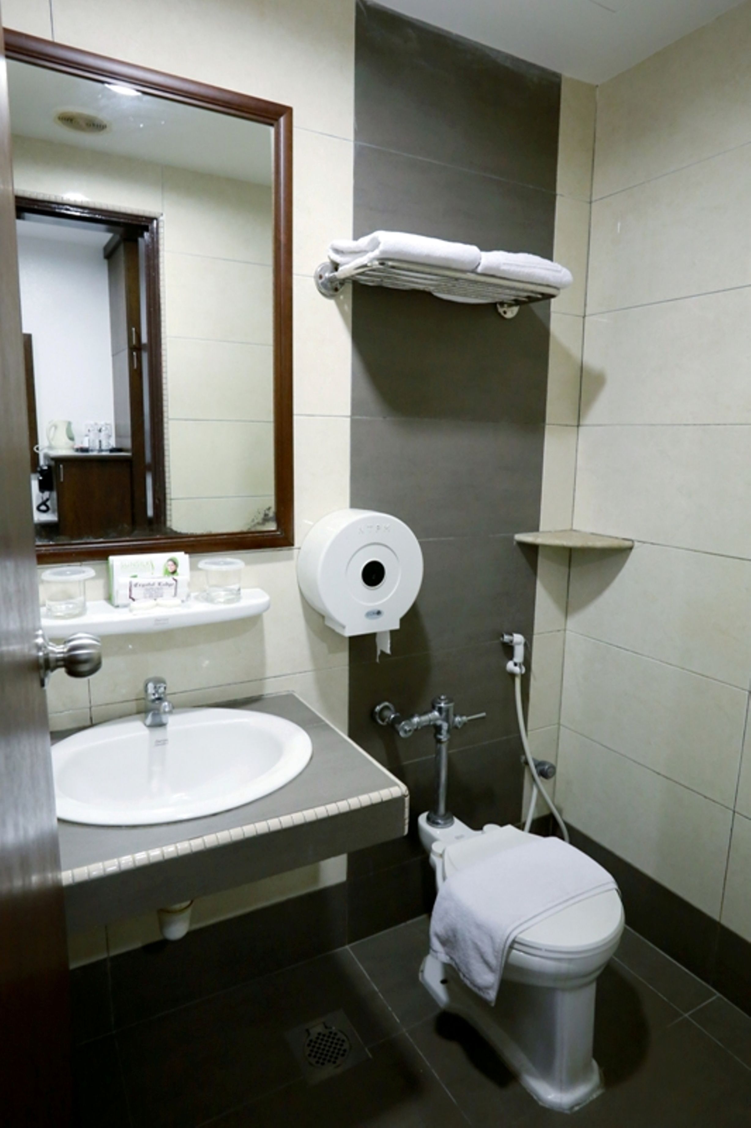 Une salle de bain équipée d’un lavabo, de toilettes et d’un porte-serviettes.