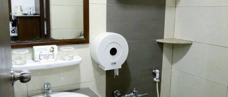 Une salle de bain équipée d’un lavabo, de toilettes et d’un porte-serviettes.