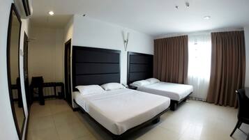 Habitación de hotel con dos camas, un escritorio y una silla.