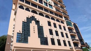 A multi-story hotel with a distinctive architectural design, featuring a central arched window and multiple balconies. - Crystal Lodge (Kota Bharu)