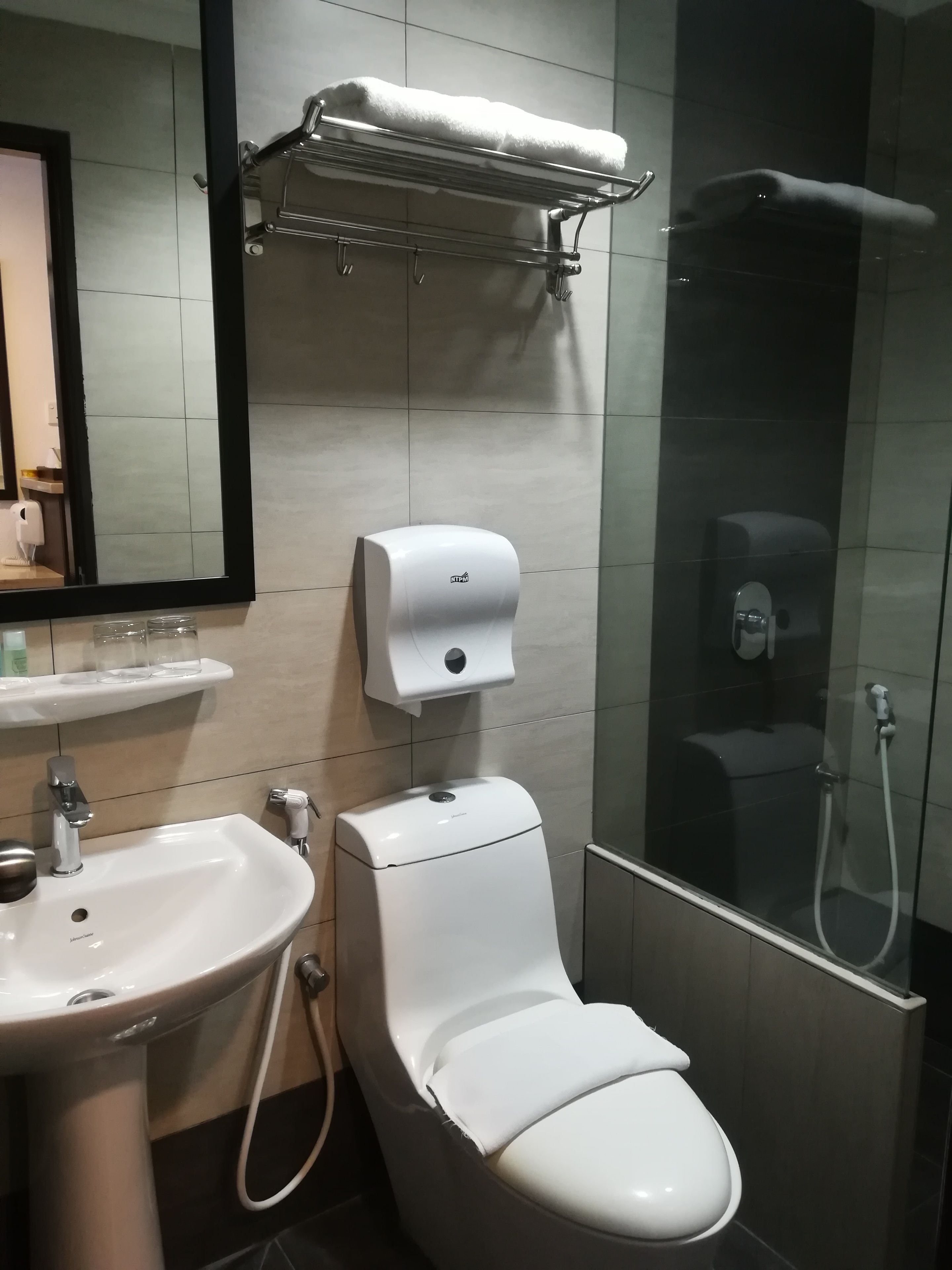 Une salle de bain moderne avec un lavabo blanc, des toilettes et une douche à parois de verre.
