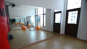 A spacious room with a large mirror, exercise balls, and a ceiling fan. - Crystal Lodge (Kota Bharu)