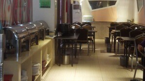 A restaurant with a buffet setup, tables, and chairs. - Jiashiting Hotel Hankou Railway Station (Wuhan)