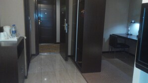 A hotel hallway with a reception desk, a door, and a small seating area. - Jiashiting Hotel Hankou Railway Station (Wuhan)