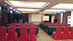 A conference room with rows of tables and chairs, a projector screen, and a podium. - Jiashiting Hotel Hankou Railway Station (Wuhan)