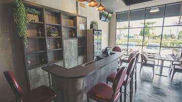 A bar area with a counter, bar stools, shelves with decorative items, and a view of the outside through large windows.