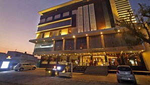 A multi-story hotel with a modern design, featuring a prominent entrance with steps and a covered area. - Hotel LN Courtyard (Ajmer)