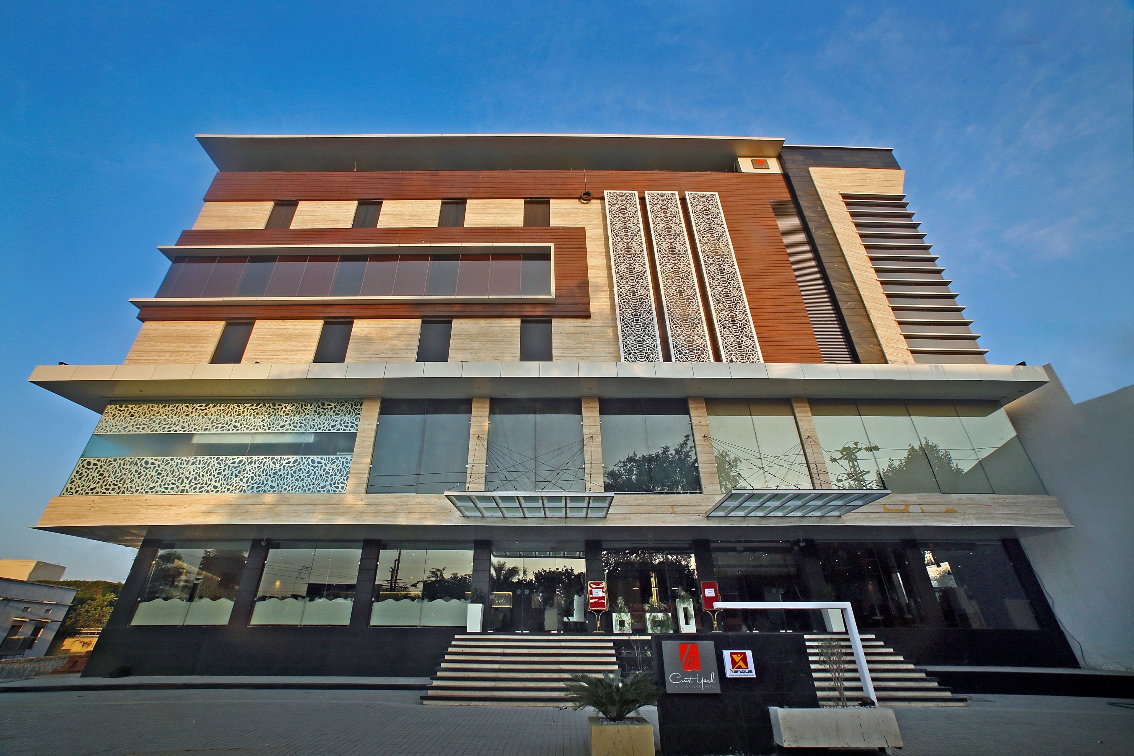 A modern building with a multi-story structure, large windows, and a prominent entrance with steps.