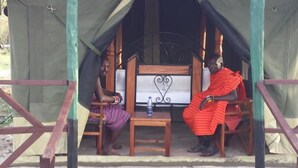 A tent with two wooden chairs and a small table. - Destiny Eco Camp (Maasai Mara)