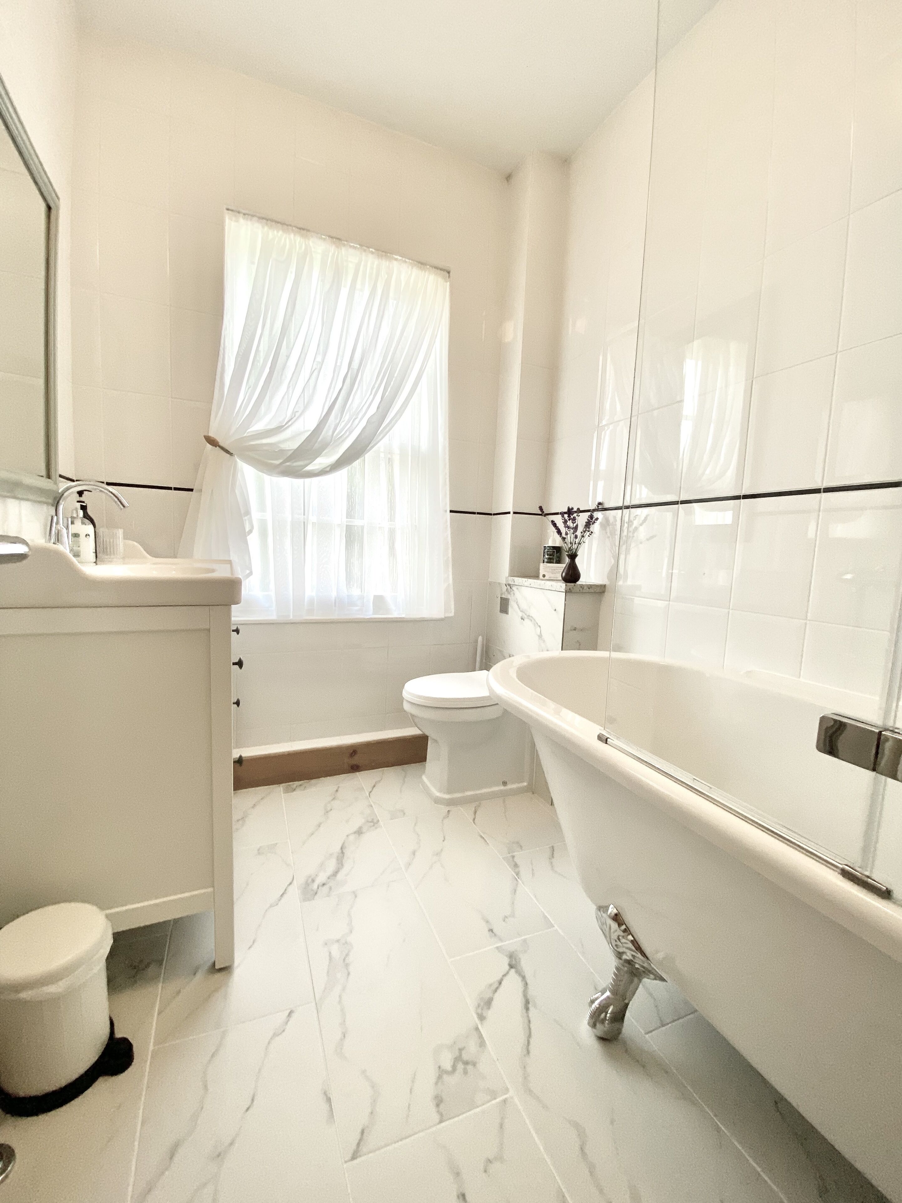 A modern bathroom with a freestanding bathtub, a toilet, and a sink.
