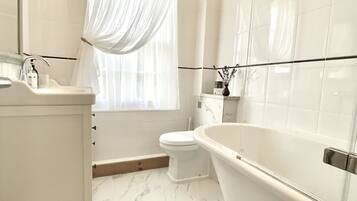 A modern bathroom with a freestanding bathtub, a toilet, and a sink.