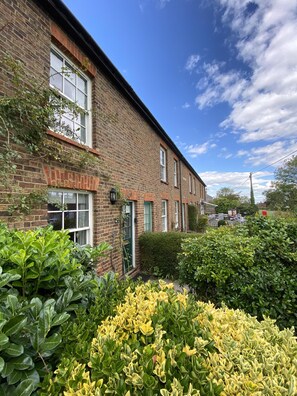 A brick house with a garden in front. - Green Cottages (Sittingbourne)