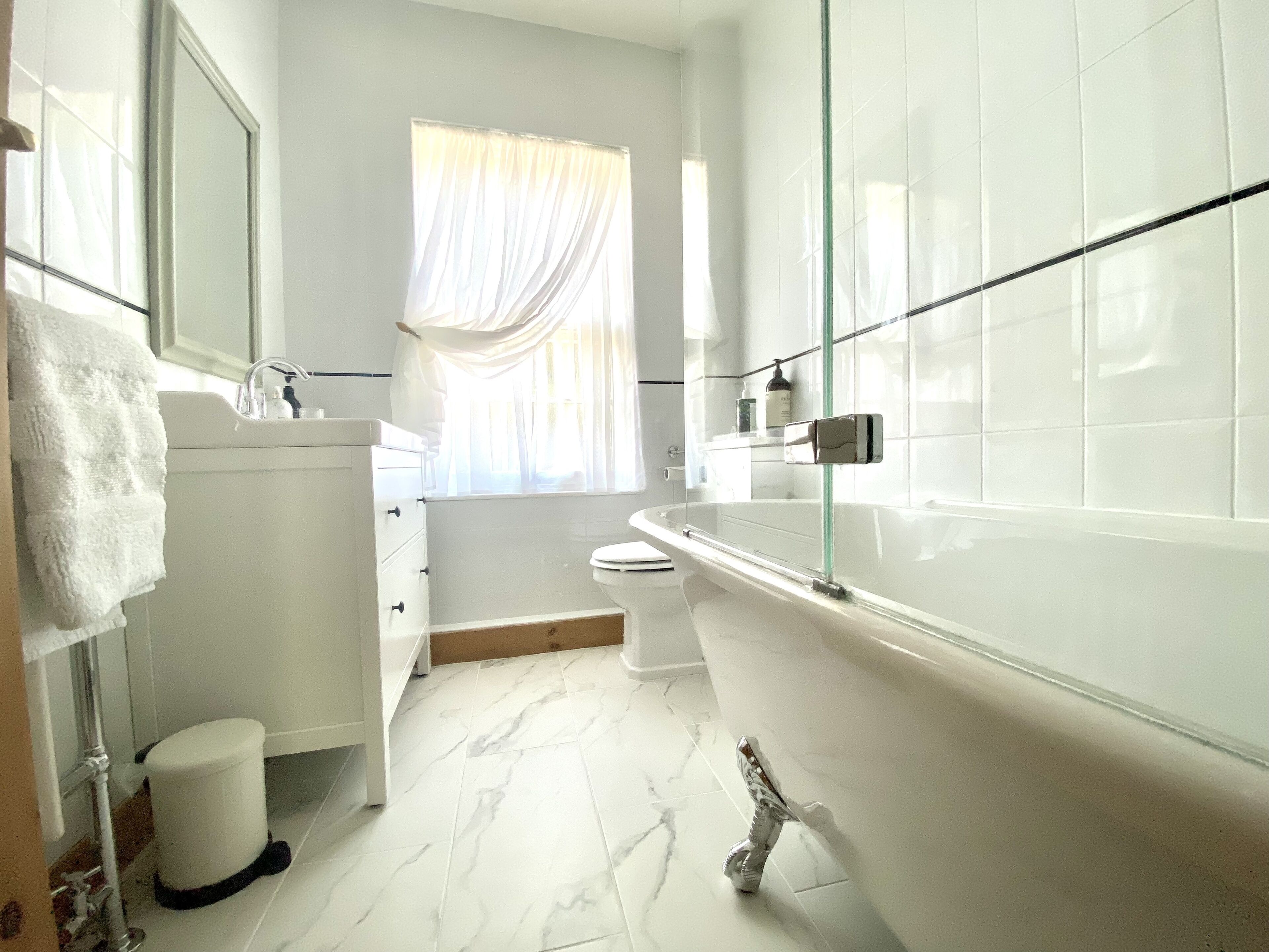 A modern bathroom with a bathtub, toilet, and sink.