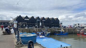 A harbor with boats docked, a pier, and a building with a pointed roof.