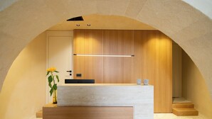 A modern bathroom with a wooden vanity, a towel rack, and a plant. - Consolato Boutique (Chania)