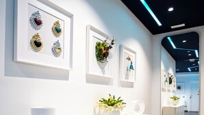A modern reception area with a white reception desk, framed artwork on the walls, and a dark tiled floor. - Skyhouse Beverello (Naples)