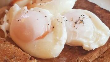 Un plato con dos huevos pochados sobre tostadas y una guarnición de frijoles.