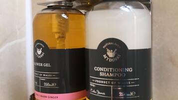 Deux flacons de produits de bain, dont l’un est étiqueté « gel douche » et l’autre « shampoing après-shampoing », et qui sont tous deux dotés d’un distributeur à pompe.
