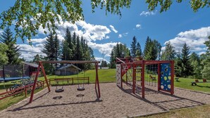 A playground with swings, a slide, and a climbing structure.