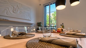 Een eettafel gedekt met placematen, glazen en bestek.
