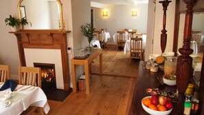 A dining area with wooden furniture, a fireplace, and a mirror. - Chantry Hotel (Bury St Edmunds)