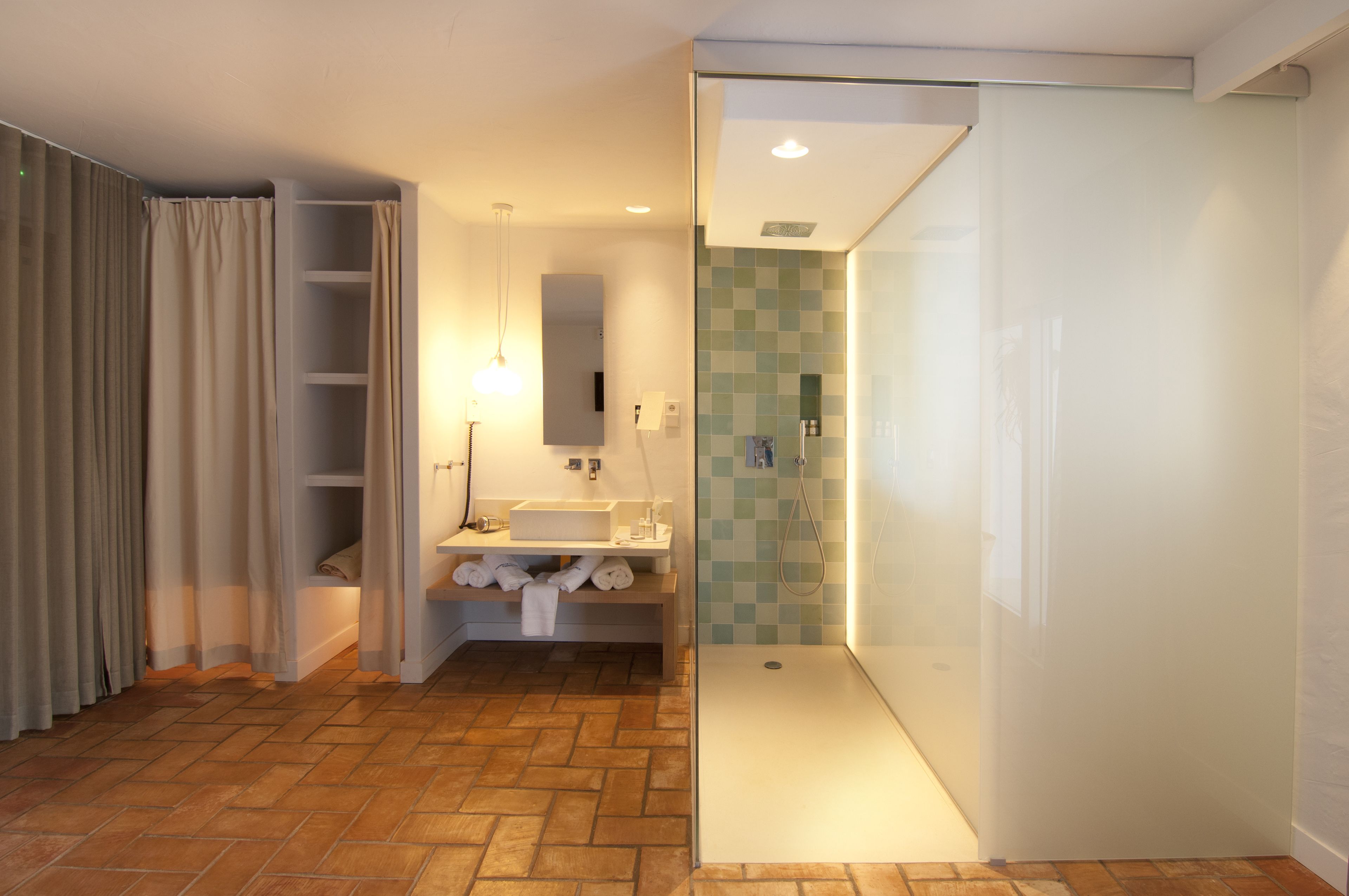 Un baño moderno con ducha, lavabo y espejo.