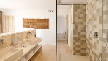 Un baño moderno con dos lavamanos, un espejo grande y una zona de ducha.