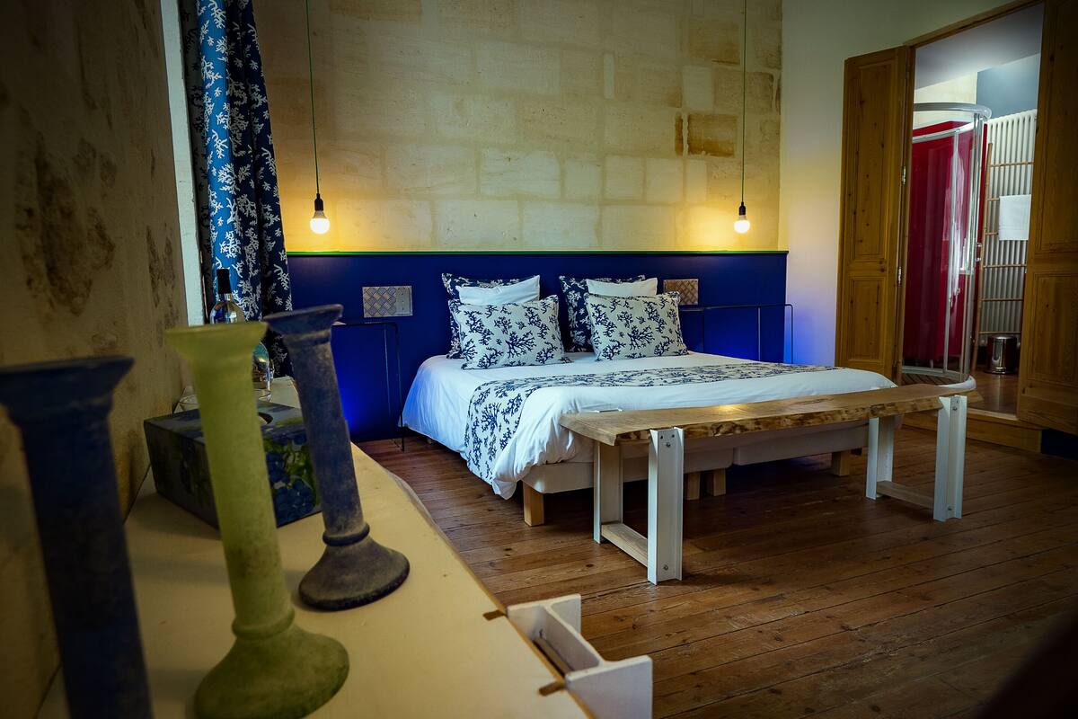 A bedroom with a bed, bedside tables, and a wooden floor.