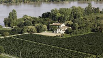 Ein weitläufiges Anwesen mit einem Haus, umgeben von üppiger Vegetation und einem Fluss.