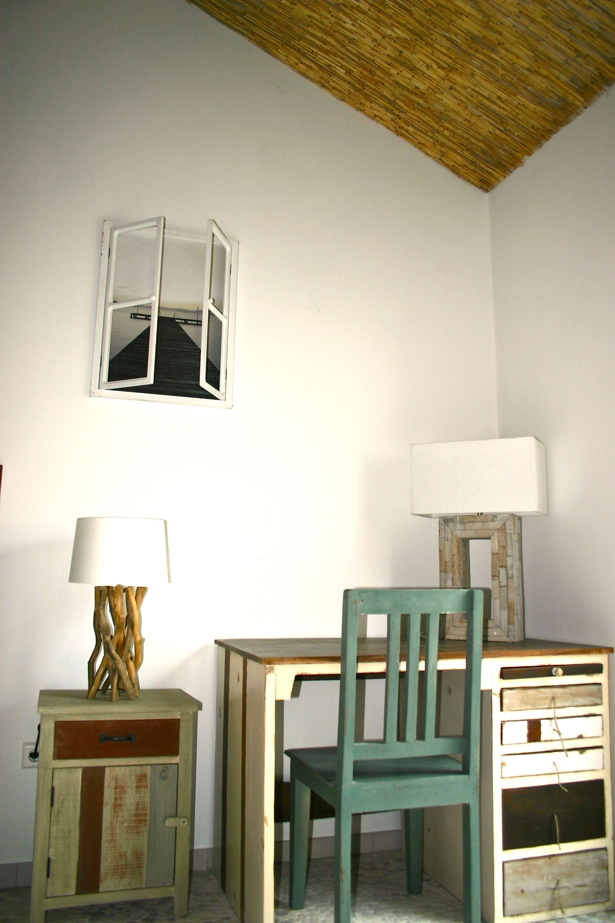 Una habitación con escritorio, silla, lámpara y armario.