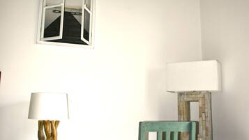 Una habitación con escritorio, silla, lámpara y armario.