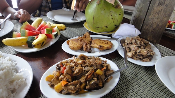 A table with various dishes including rice, meat, and fruit.
