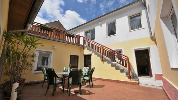 Un edificio de dos pisos con escaleras y un patio.