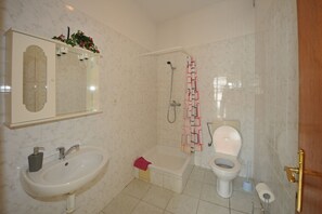 Une salle de bain avec un lavabo, des toilettes et une baignoire.